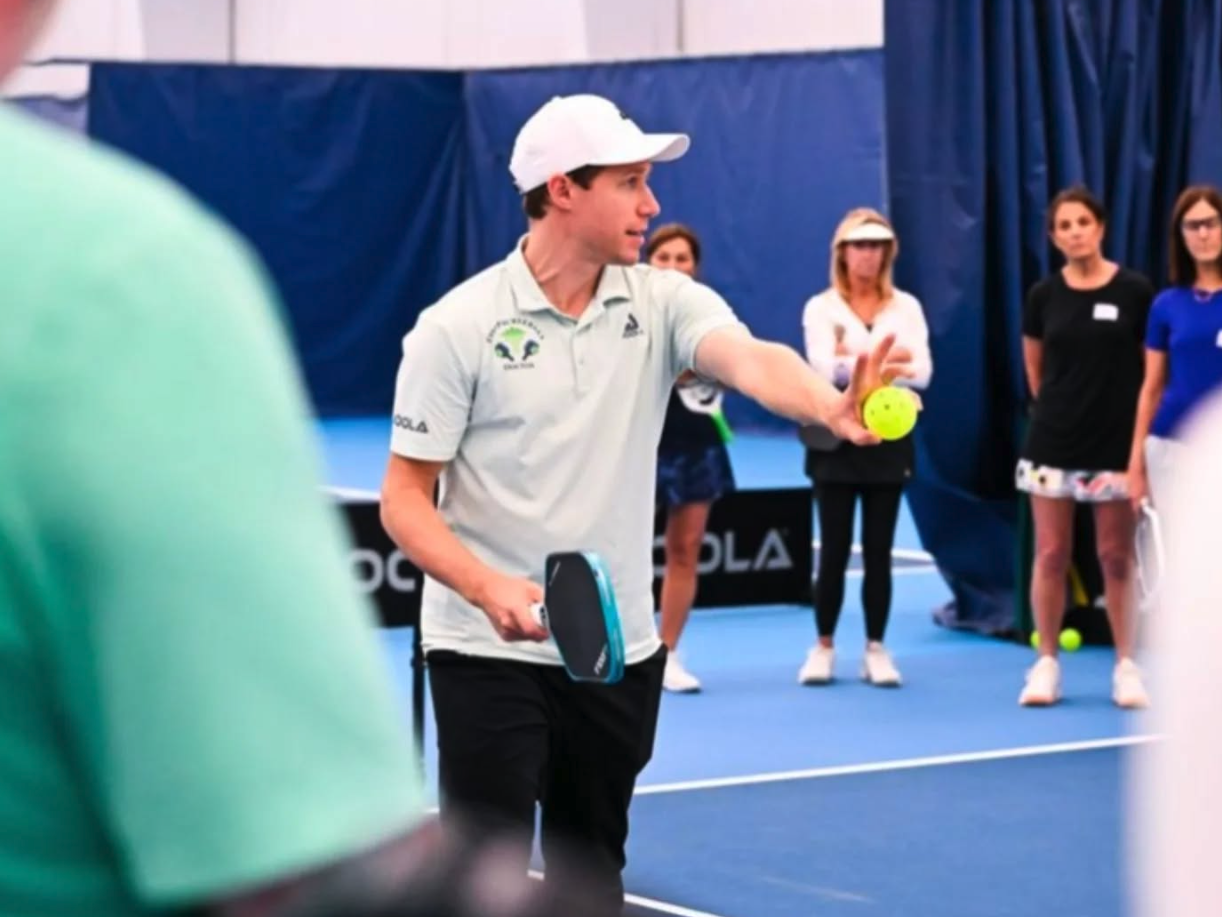 Dr. Noe Sariban coaching pickleball players on court